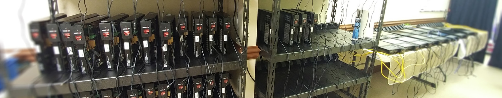 Large metal shelves holding many Tempus Pro Data Collection Terminals side-by-side