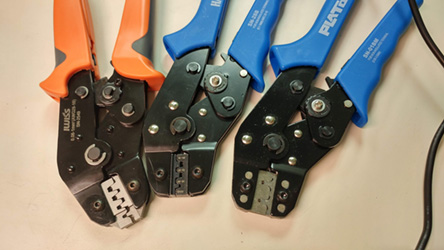 Three of Focus Inc's colorful wire crimping tools sitting side-by-side